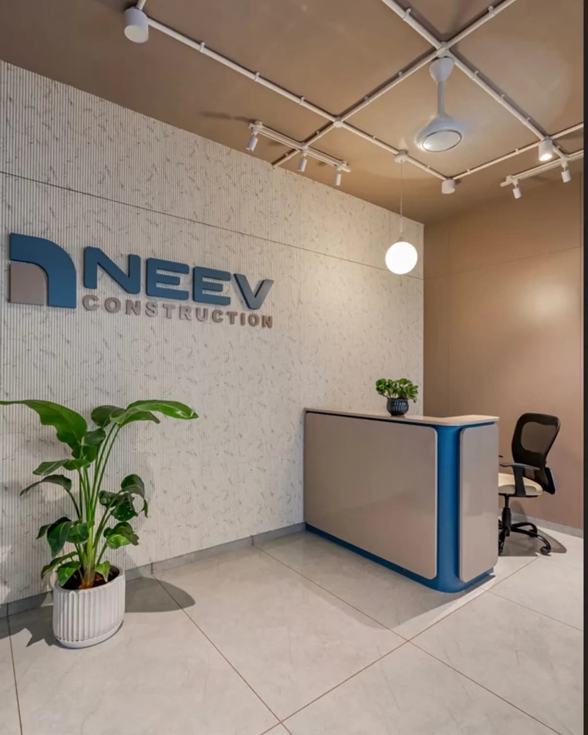 Reception area at Neev Construction head office in Vadodara featuring the company logo.